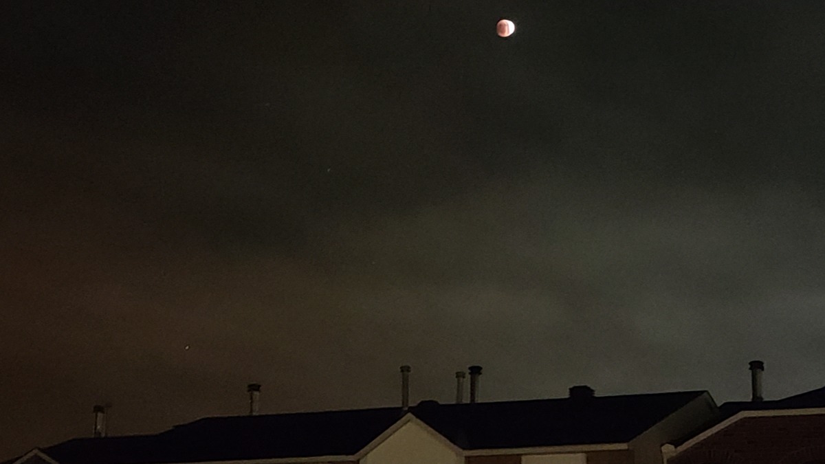 Un lector de Ottawa, Canadá, tomó una foto del eclipse lunar sobre los tejados el 15 de mayo de 2022.