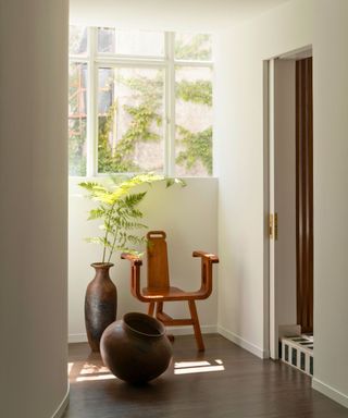 hallway with wooden chair and pottery