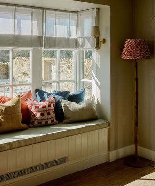 Window seat with cushions and roman blinds