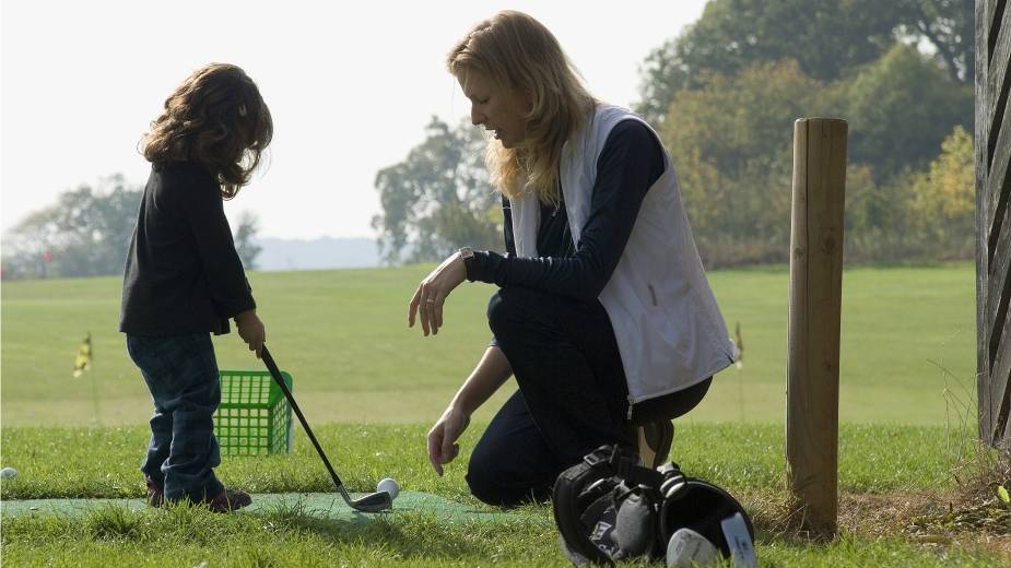 Young girl having a golf lesson
