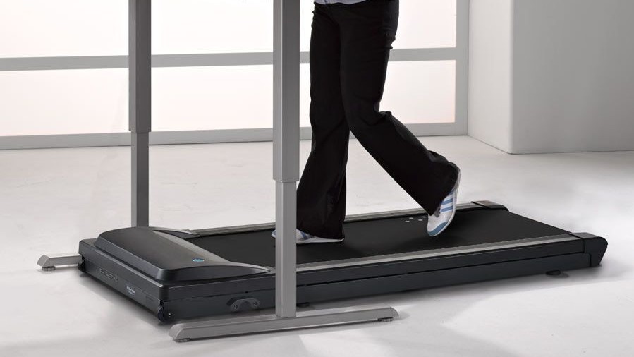 a photo of a woamn walking on the lifespan walking treadmill