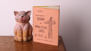 statue of cat next to TS Eliot's poetry book