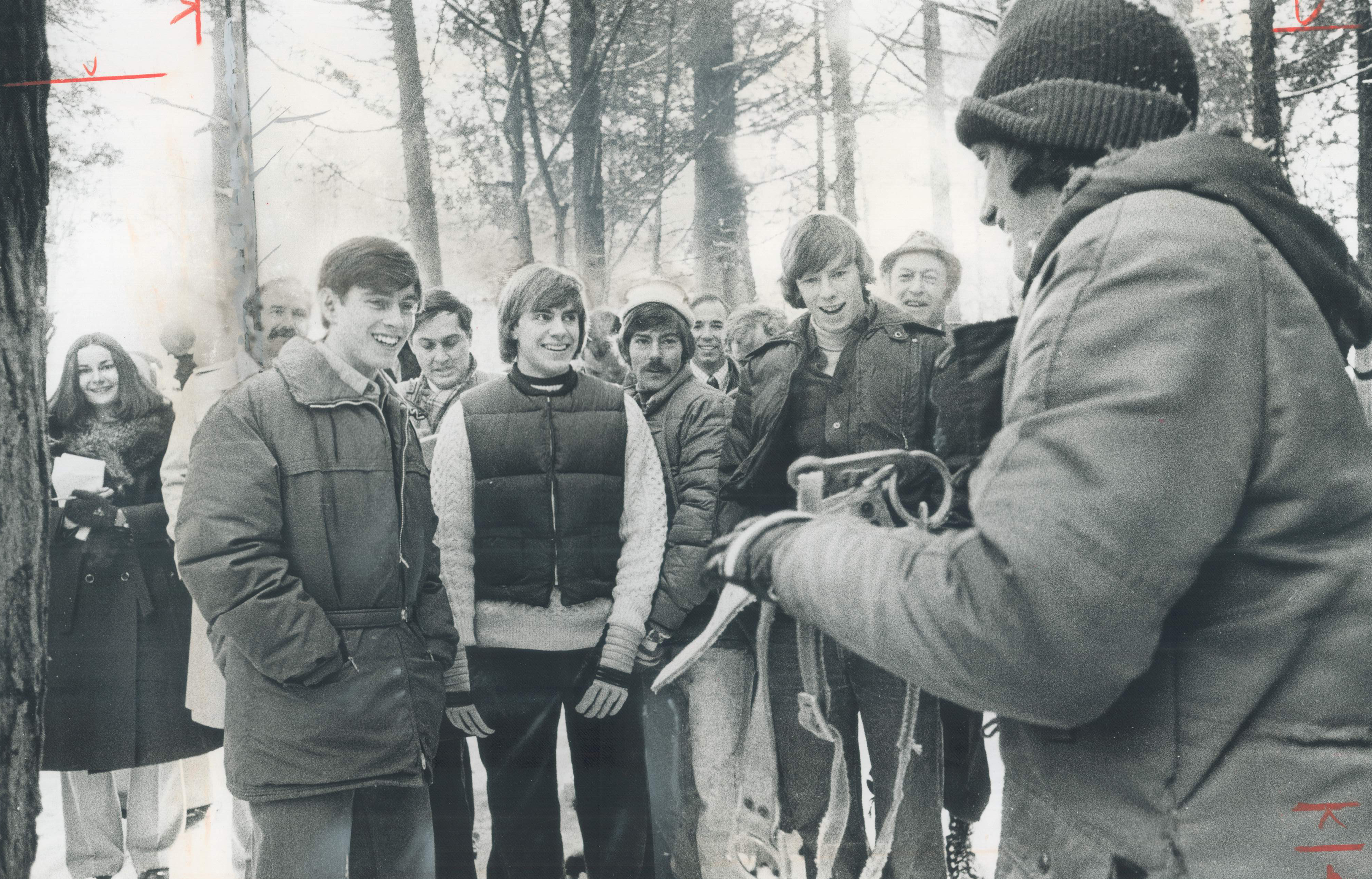 Teenage Prince Andrew wearing a coat standing with boys in a forest