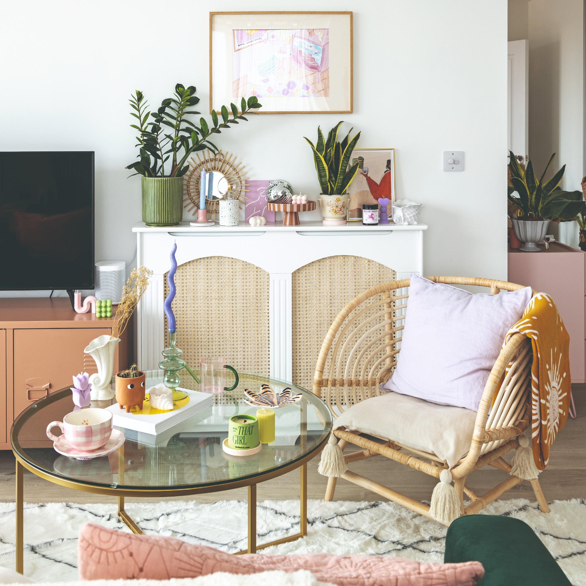 A living room with a TV on a free-standing Mustard Made locker used as a media unit and a rattan accent chair