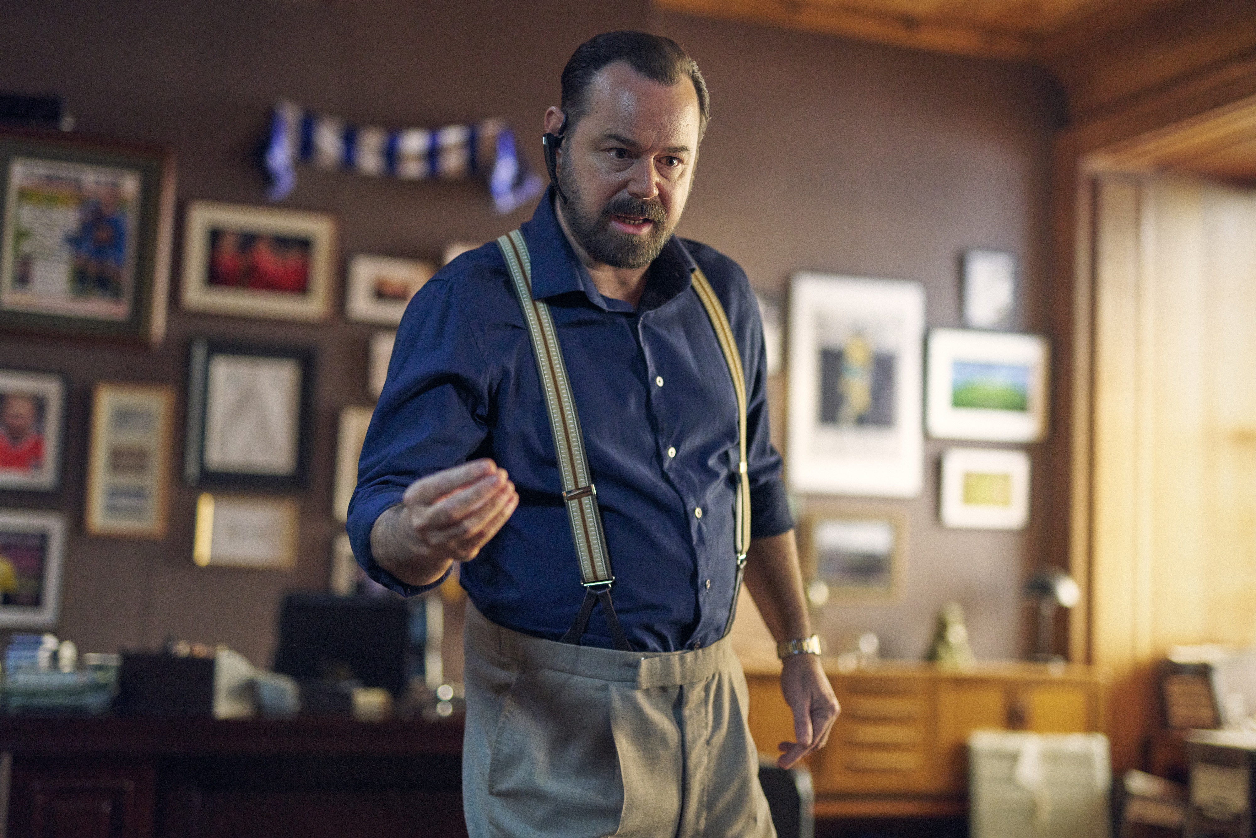 Actor Danny Dyer wearing braces in an office playing football agent Jimmy Banks in the film One Last Deal