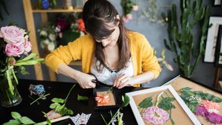 A lady creates framed cut pressed flowers