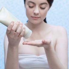 Woman Putting Cream on Hand
