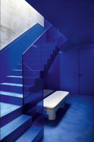 Blue hallway with blue glass balustrade staircase