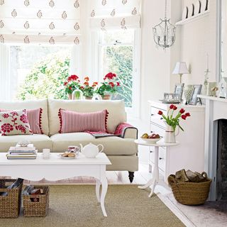 Living room with bay windows and cream sofa with red striped cushions