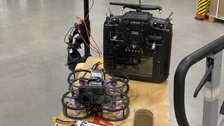 Drones Cinewhoop FPV en una mesa junto a un controlador en la fábrica Tesla Giga Berlin
