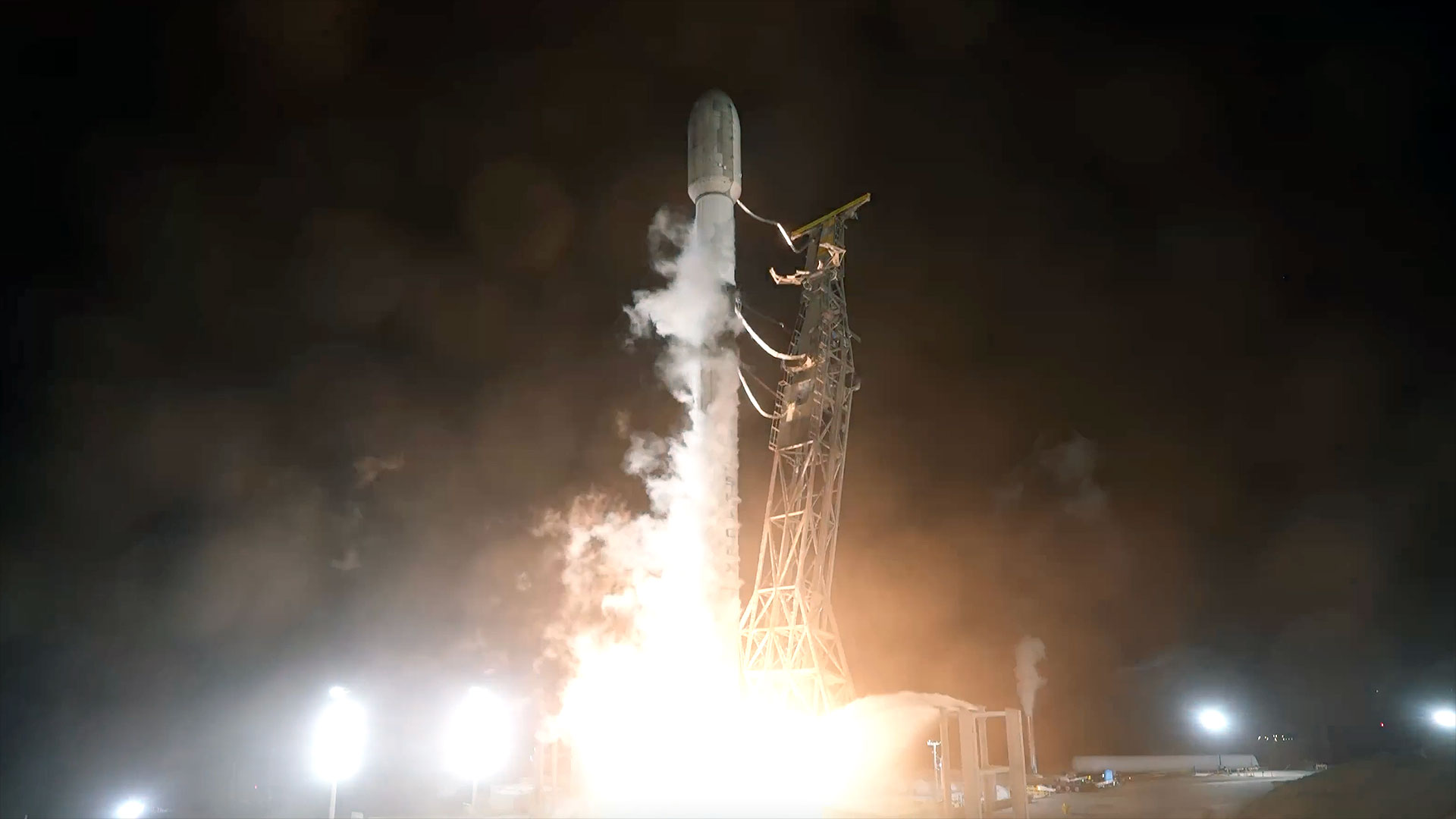 an uncrewed orbital class rocket lifts off into the pitch black sky of an early morning launch
