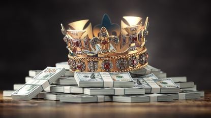a jeweled crown placed on top of stacks of hundred-dollar bills