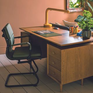 Mid century desk in home office with black office chair.