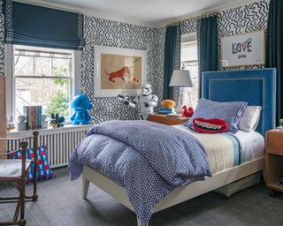 A boys bedroom idea with zigzag wallpaper and teal blue blinds