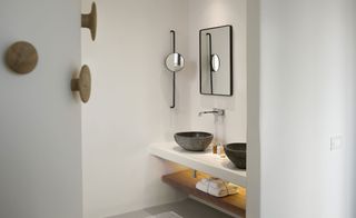 Bathroom with stone/marble sinks and mirror with makeup mirror attached to side wall