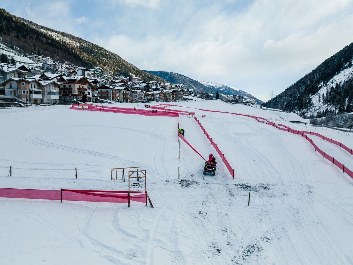 The organisers work in the snow to set-up the barriers at the Val di Sole