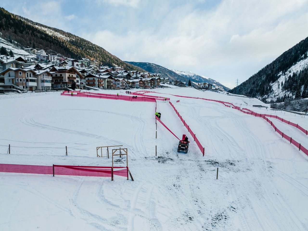 The organisers work in the snow to set-up the barriers at the Val di Sole
