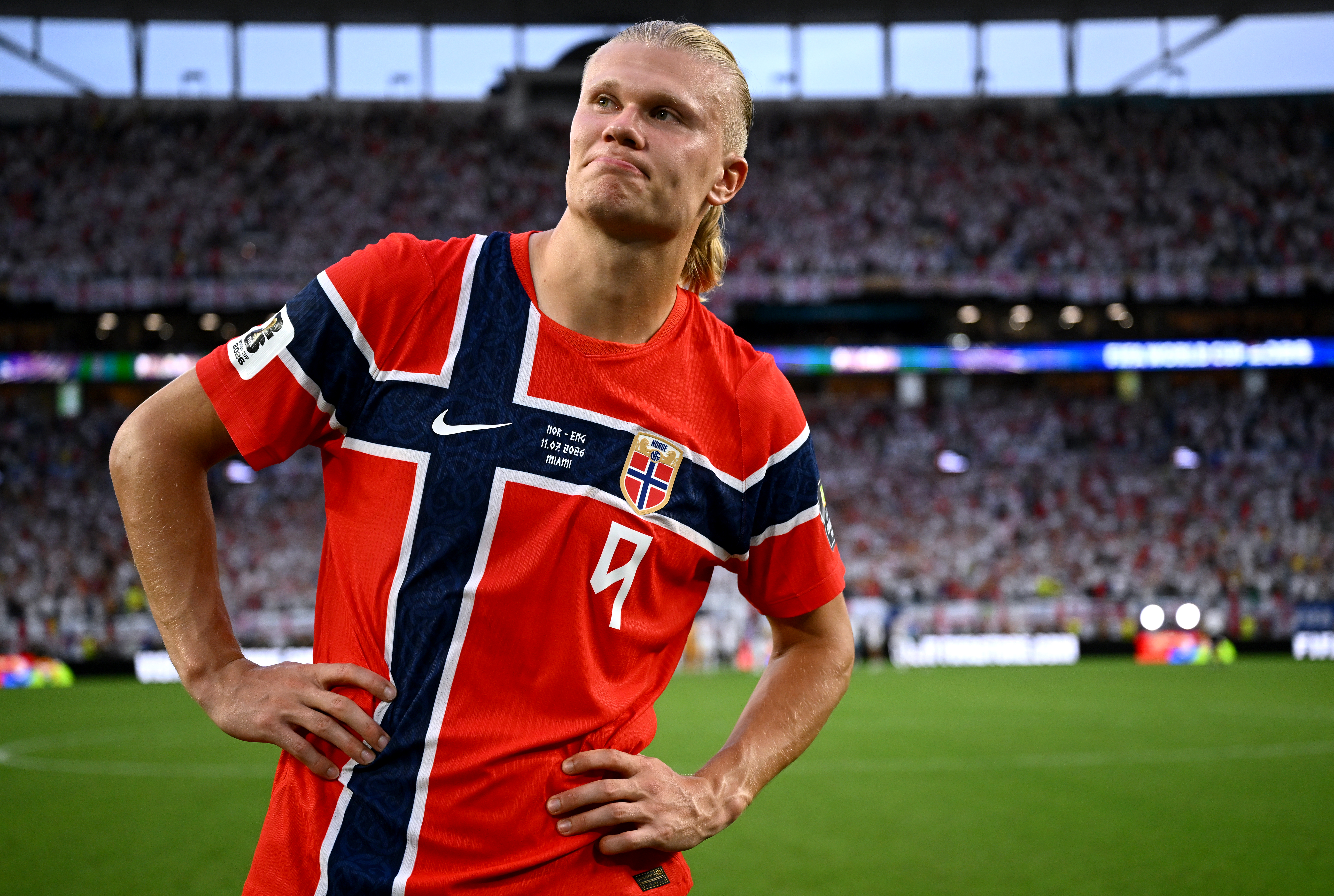 Erling Haaland, hands on hips, looking dejected.