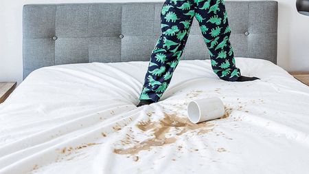 Child spilling drink on Co-Op Goods mattress protector