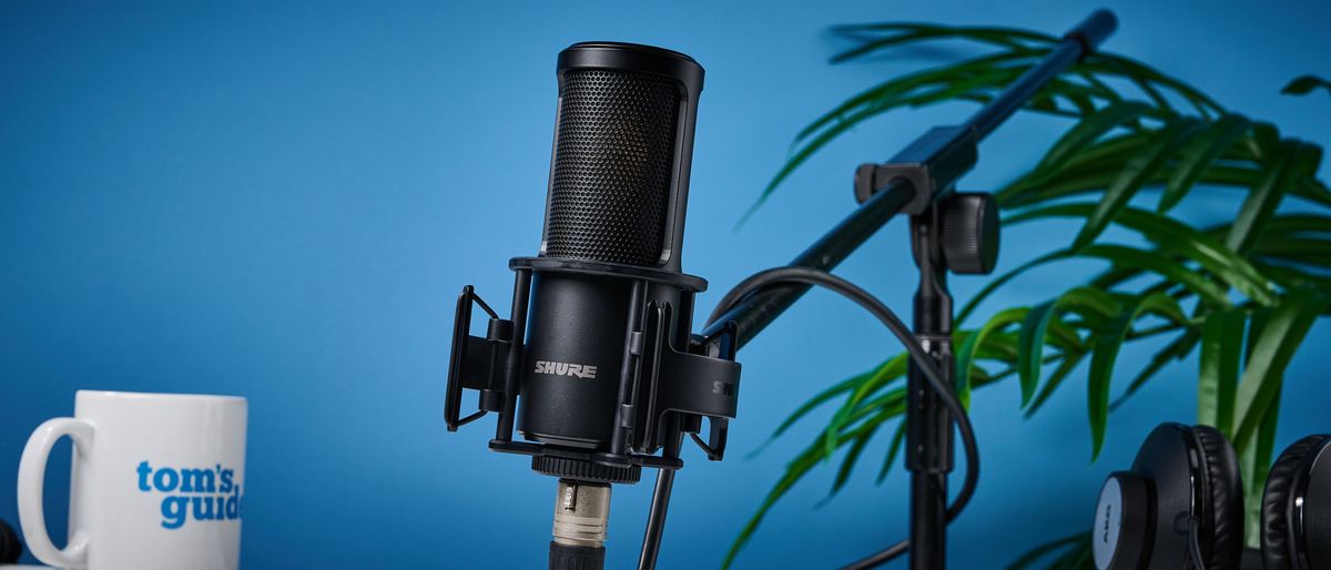 the Shure sm4 condenser musician microphone photographed against a blue background with a physical magnetic pop filter