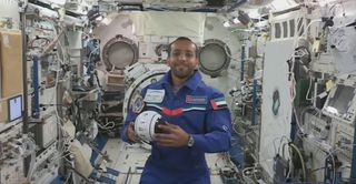 UAE astronaut Hazzaa Ali Almansoori demonstrates the small INT-Ball robot for students and the Japanese Aerospace Exploration Agency inside the Japanese Kibo module on the International Space Station.