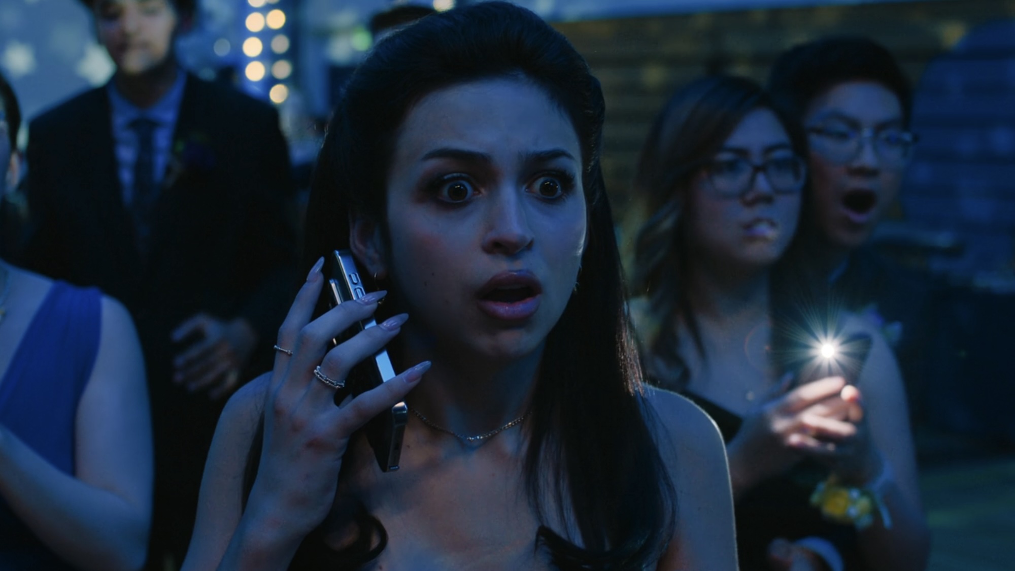 Tina looking shocked holding her phone at prom in Carrie's finale.