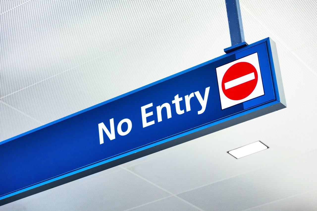 &quot;no entry&quot; sign hanging from airport ceiling