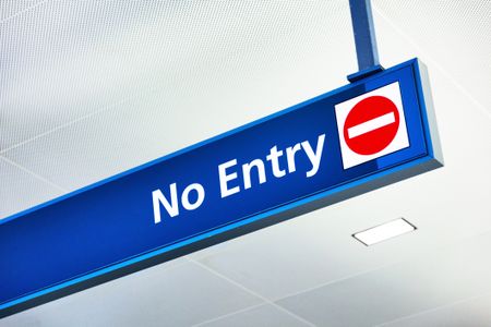 "no entry" sign hanging from airport ceiling