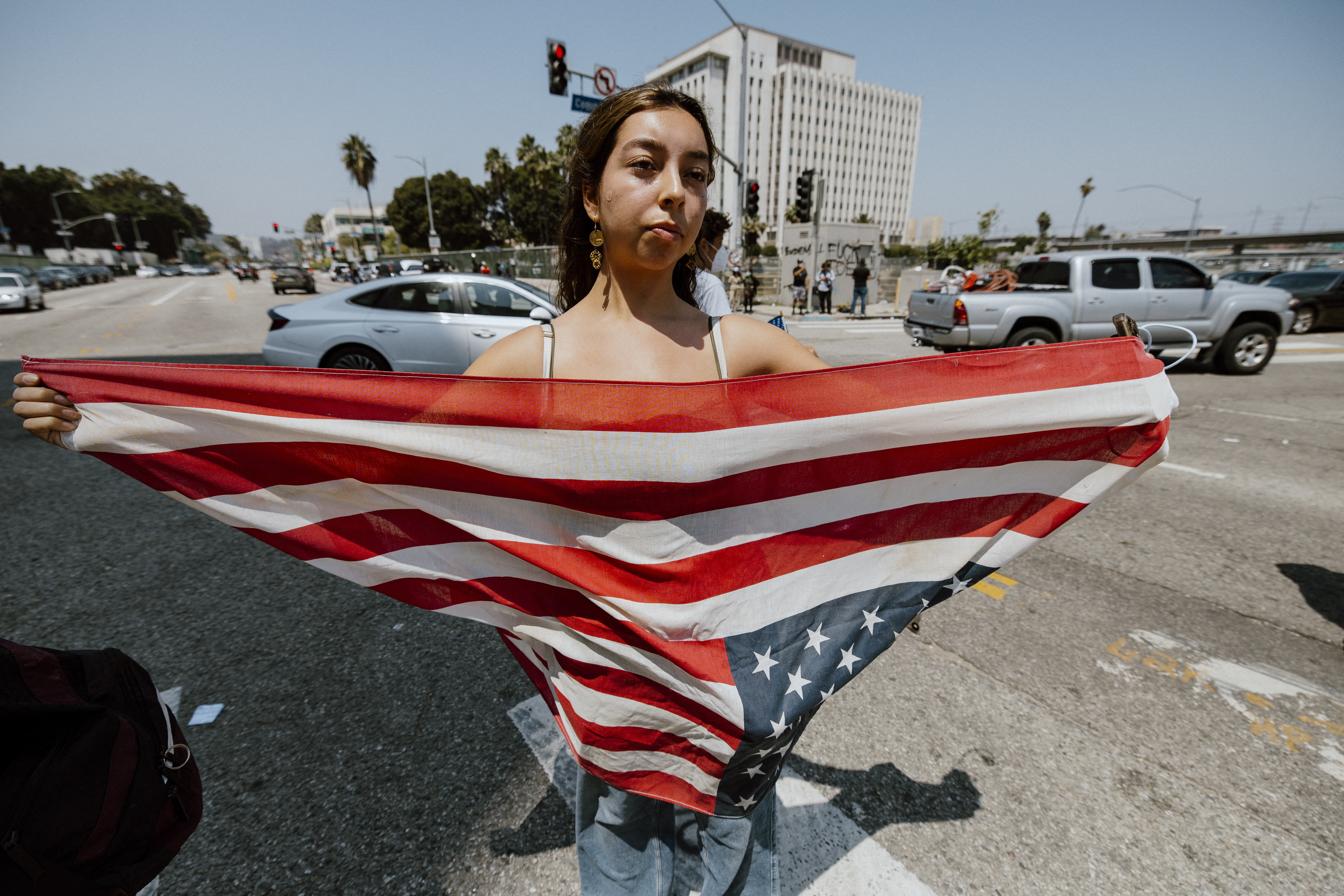 A woman holds out a U.S. flag as protesters continue anti-ICE demonstrations in Los Angeles, California, on June 9, 2025.