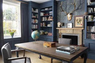Blue Georgian-style study with desk, globe and picture wall