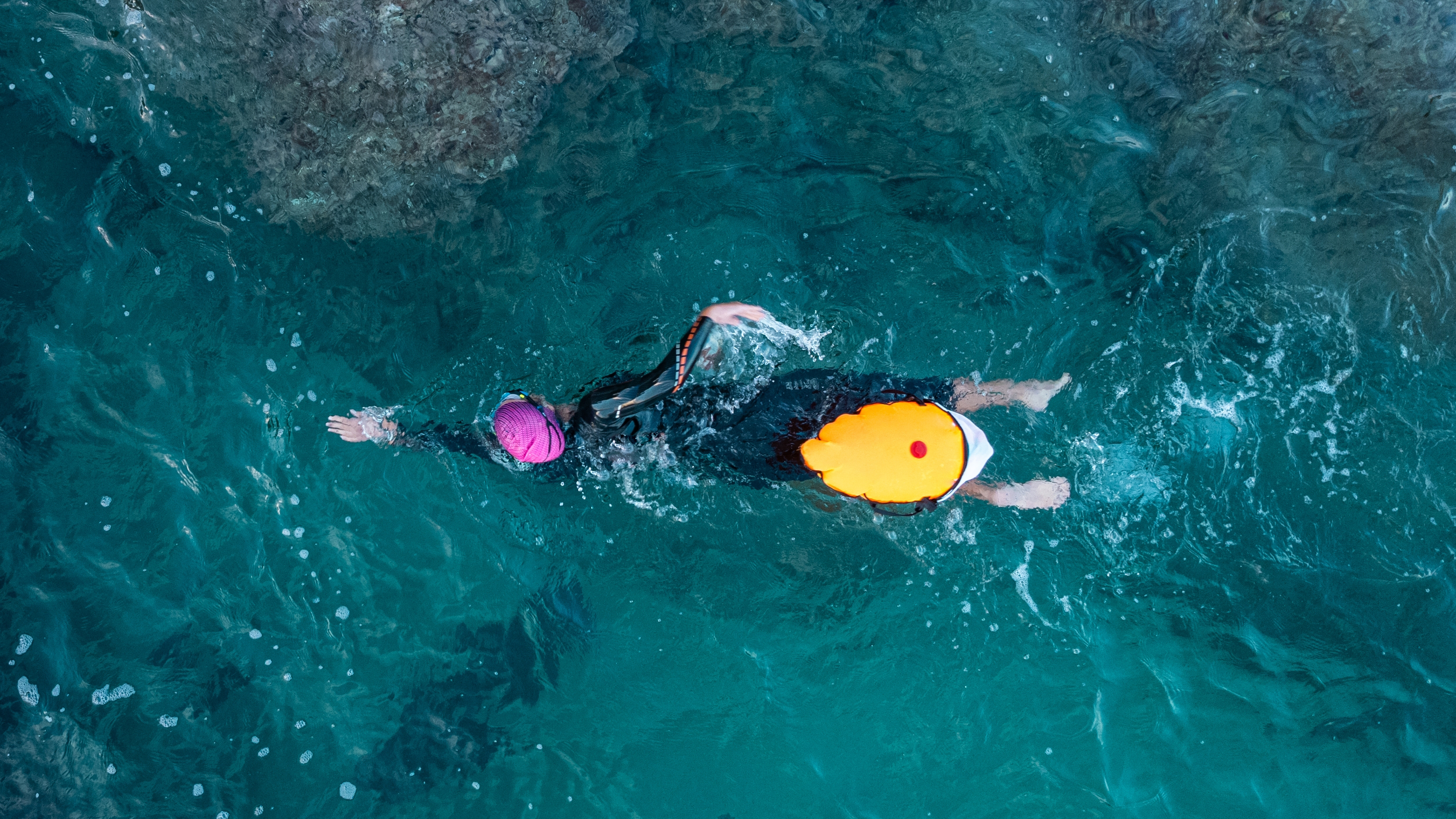 A top down view of an open water swimmer with a tow float