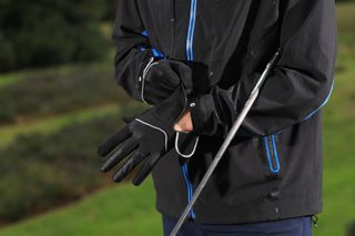 A golfer adjusts his gloves