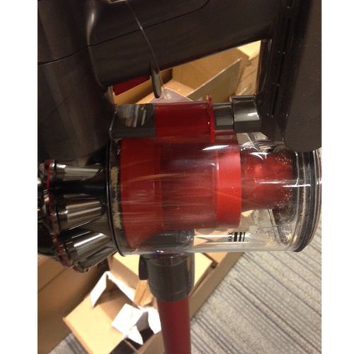 The collection bin on the V6 flips open from the bottom, just like on the V6 standard stick vac.