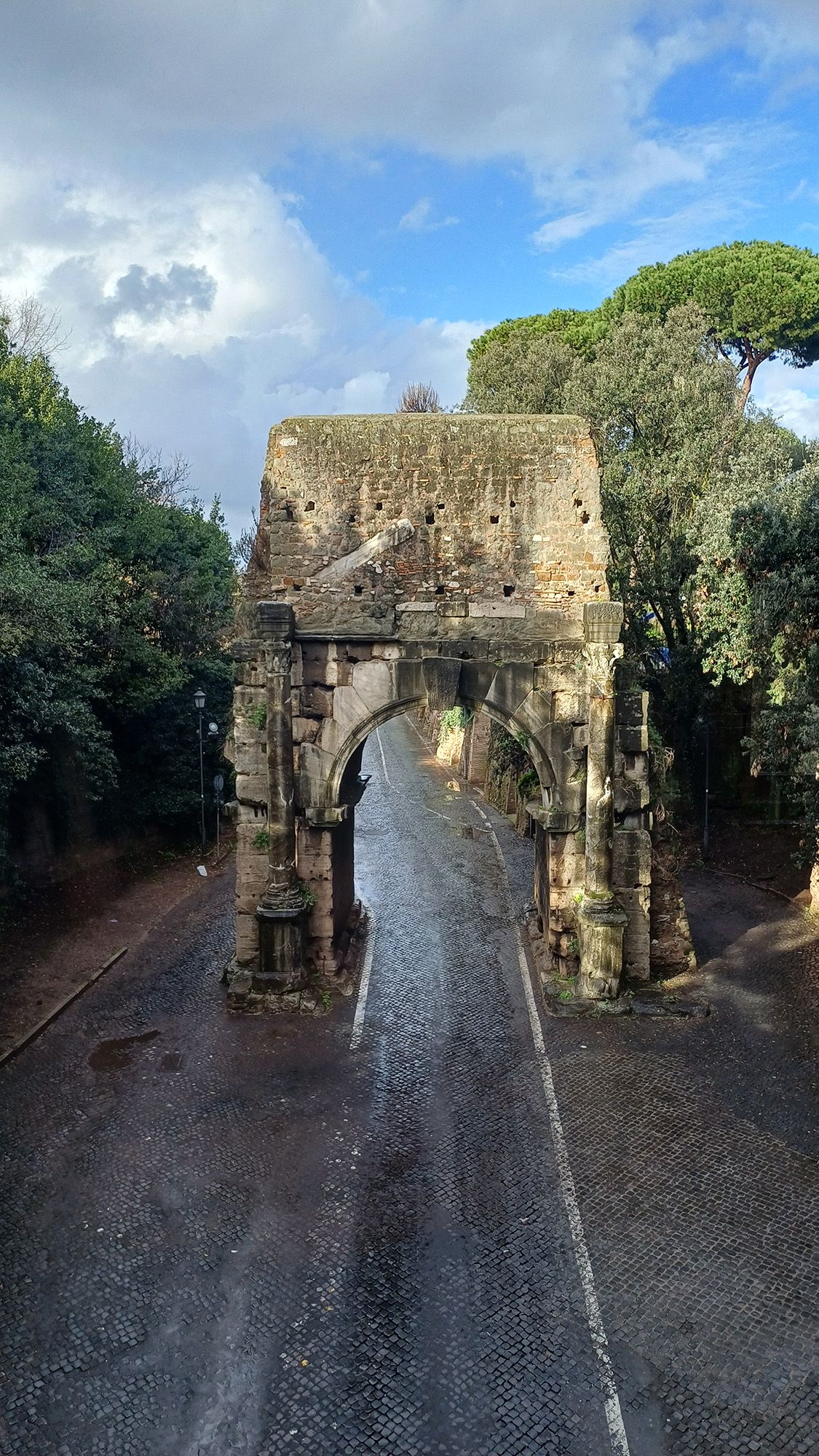A stone archway is seen above a road.