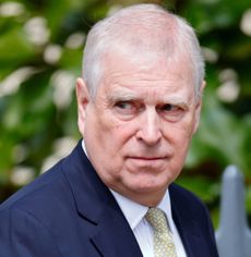 Prince Andrew wearing a blue suit and scowling