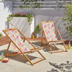 garden area with chairs and white wall