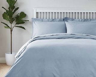 Easycare 100% Cotton Powder Blue Duvet Cover on bed, white wooden bed frame with slatted headboard and artifical plant beside the bed