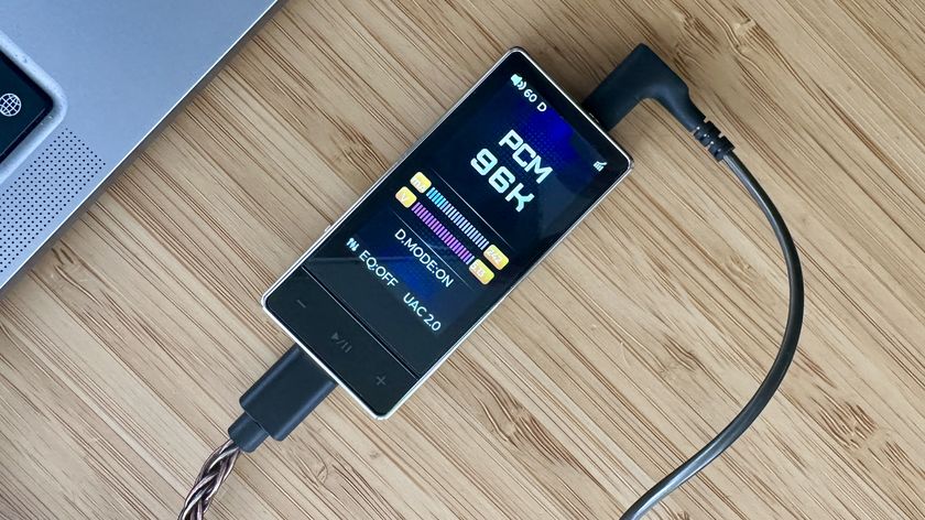 FiiO QX13 headphone amp/DAC on a wooden surface