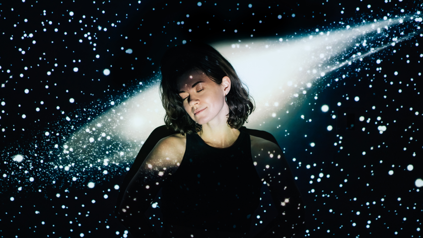 a photo of a young woman with her eyes closed, as if sleeping, with an image of space projected over her