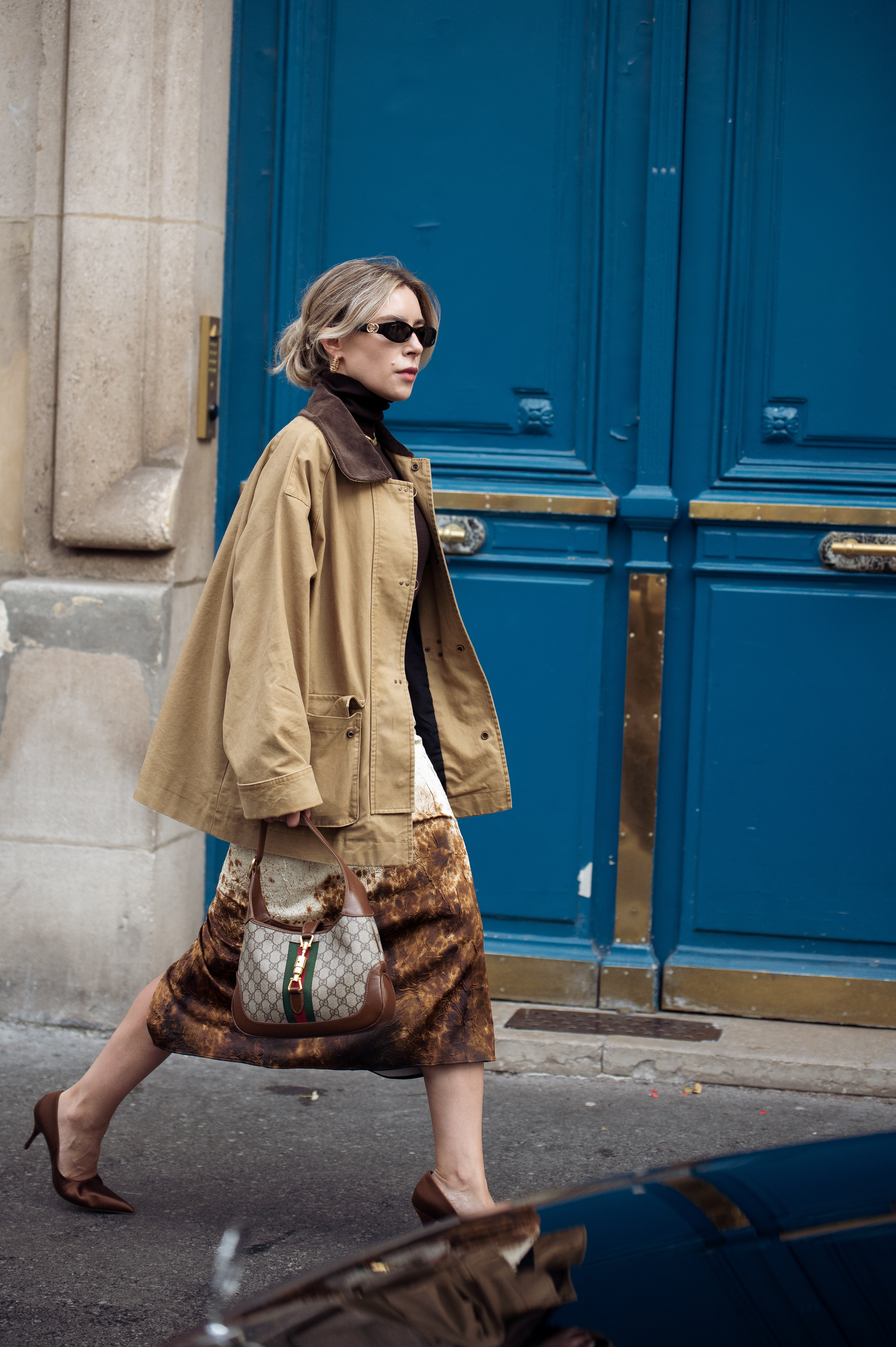 PARIS, FRANCE - SEPTEMBER 30: Olga Naumova wears beige and brown midi skirt, brown top, beige jacket and sunglasses outside the Stella McCartney show during Womenswear Spring/Summer 2025 as part of Paris Fashion Week on September 30, 2024 in Paris, France. (Photo by Raimonda Kulikauskiene/Getty Images)