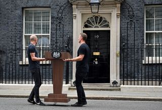 Downing Street lectern carried by two members of staff for Boris Johnson