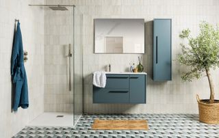 bathroom with wall mounted vanity, tall storage cabinet and walk in shower
