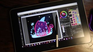A Wacom One pen display with Corel Painter 2019 running and an illustration of a small pink ghost cat wearing a wizard hat.
