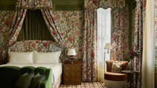 Chintz-drenched Dallas bedroom featuring a canopy bed, fringed accent chair, and olive green accents