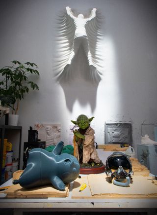 A desk at Daniel Arsham's studio with a 3D printed Pikachu model and a Yoda statue