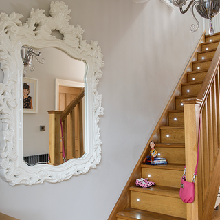 wooden stairway with walled mirror