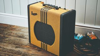 Supro Delta King 12 on a wooden floor with pedals and cables behind 