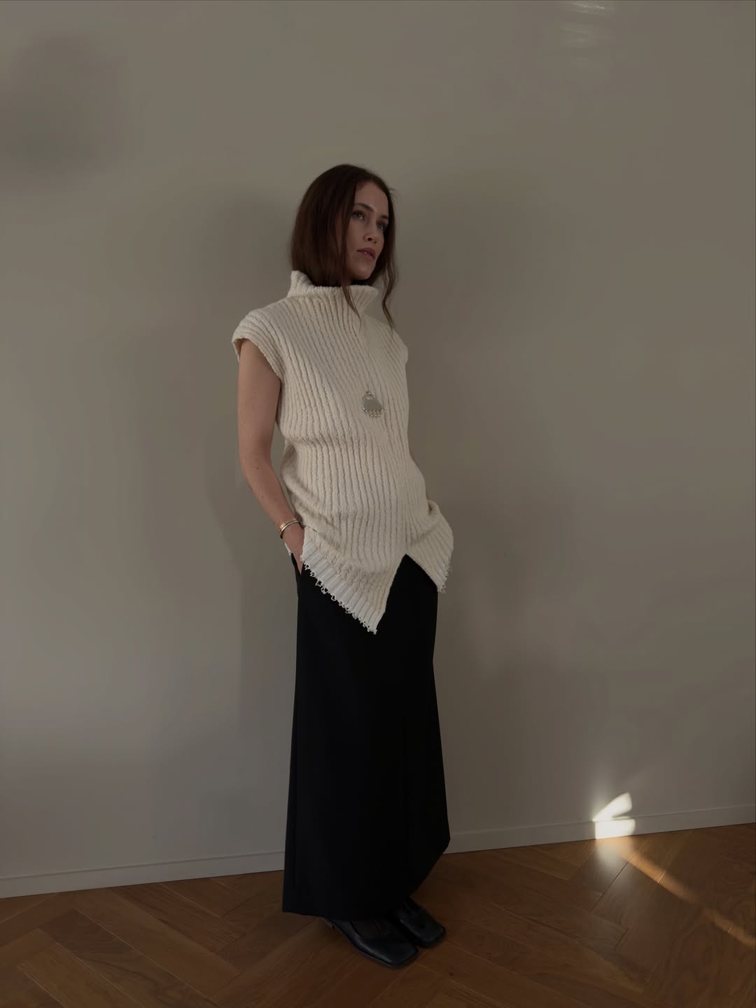 Annabel in a long knit vest and black skirt