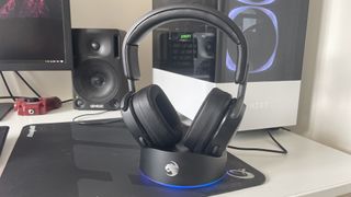 Roccat Syn Max Air headset in charging cradle on a gaming desk next to a PC