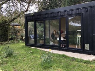 converted shipping container garden room painted all black
